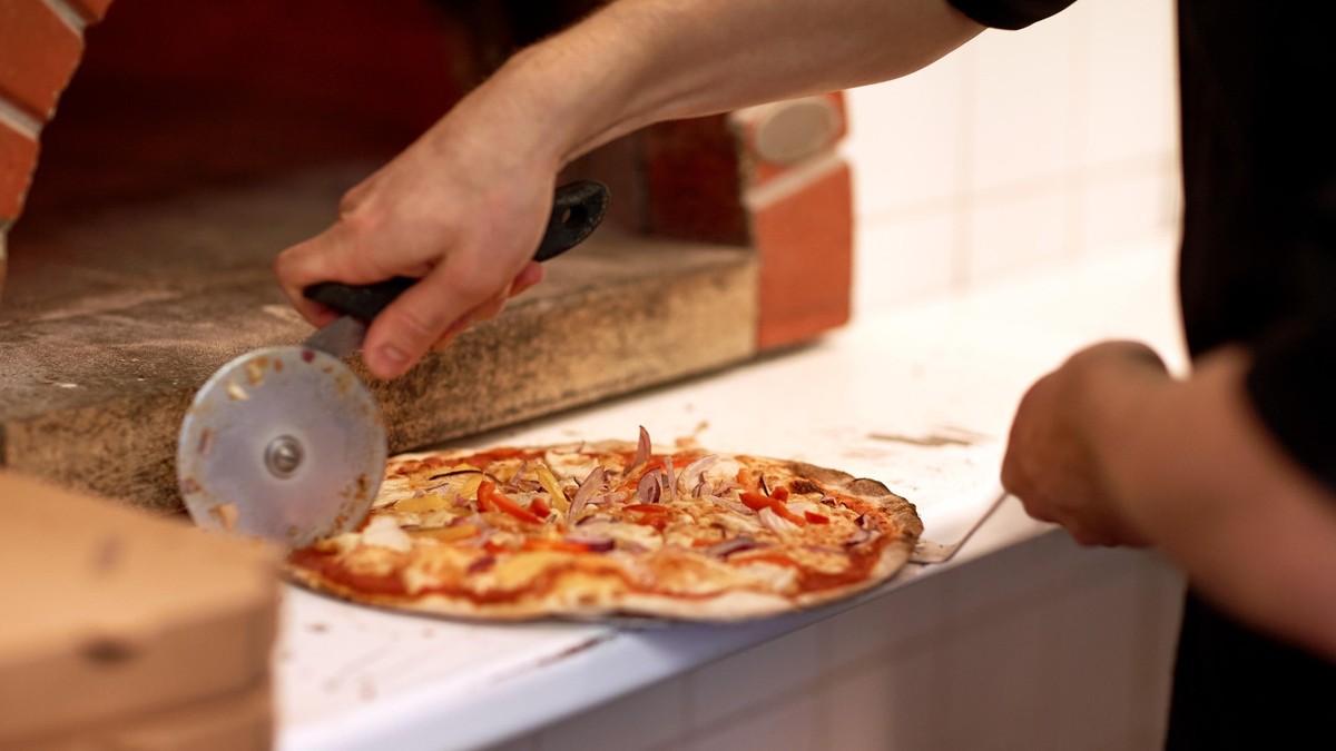 Bucătar surprins în timp ce taie pizza