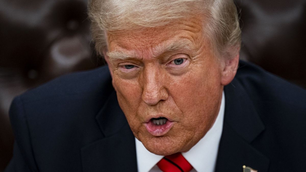 Donald Trump, președintele Statelor Unite ale Americii, în prim-plan, îmbrăcat într-un costum închis la culoare, cravată roșie și cămașă albă