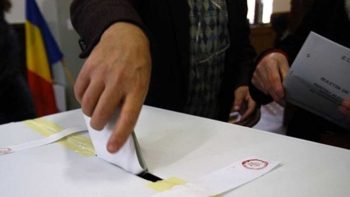 Un alegător introduce în urnă buletinul de vot