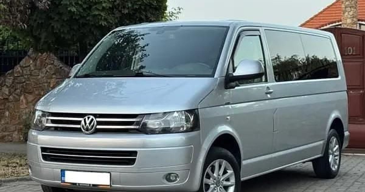 O mașină Volkswagen Caravelle, 2012, de culoare argintie.