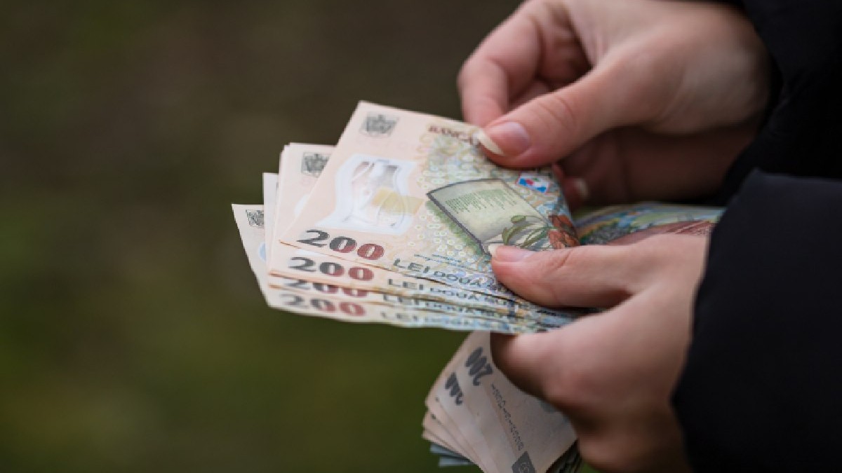 Un prim-plan cu mâinile unei femei care numără bani