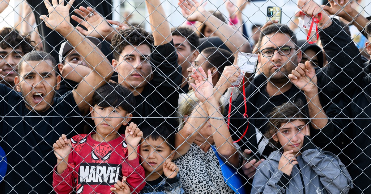 Tabără de imigranți din Grecia, copii și tineri în spatele unui gard.
