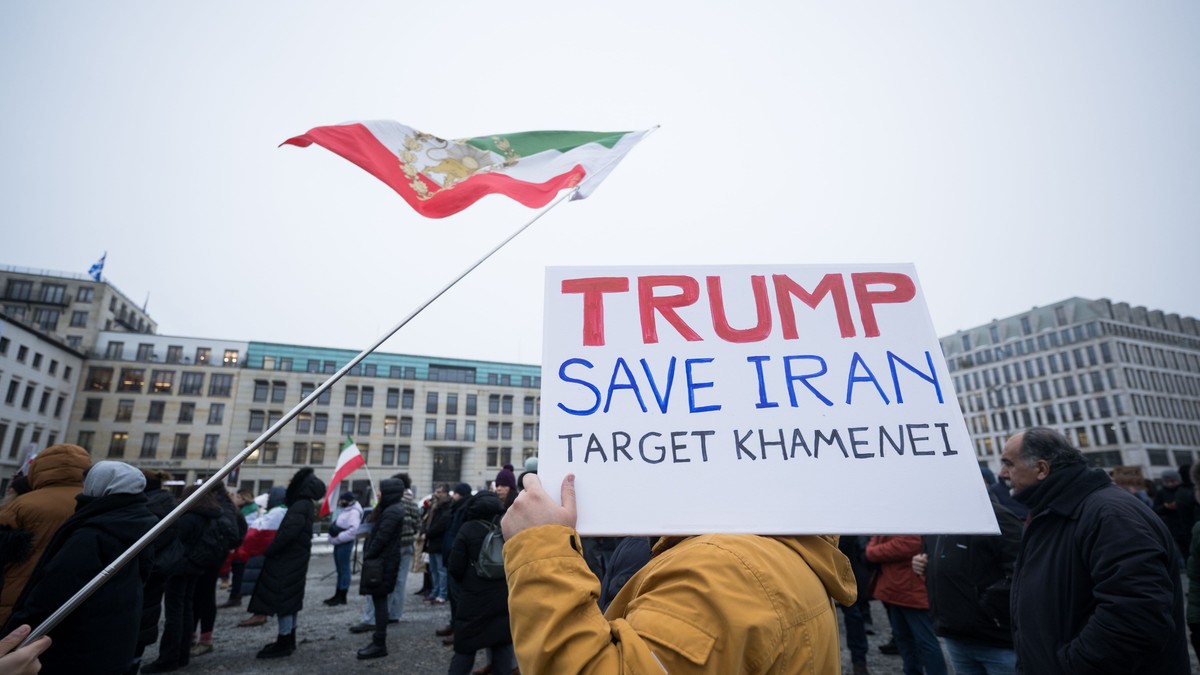 Un protestatar împotriva regimului ayatollahului Ali Khamenei ține ridicat un semn în care îi cere lui Donald Trump să îl ucidă pe acesta. Fotografia este din Berlin.