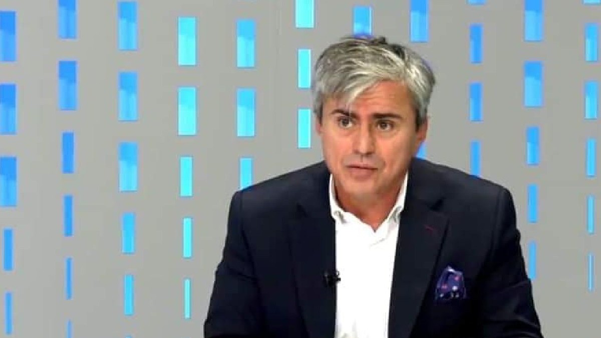 Gabriel Biriș îmbrăcat în sacou negru, cămașă albă, într-un studio TV