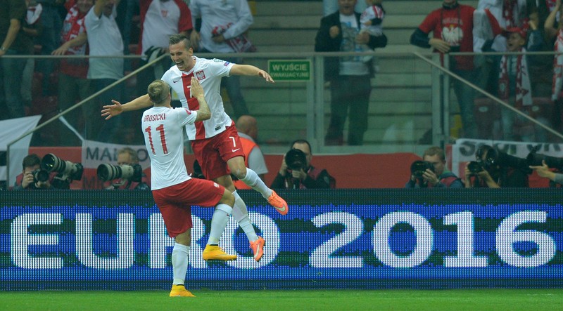 Arkadiusz Milik (dreapta) sărbătorește cu Kamil Grosicki marcarea primului gol în partida cu Germania. FOTO: EPA