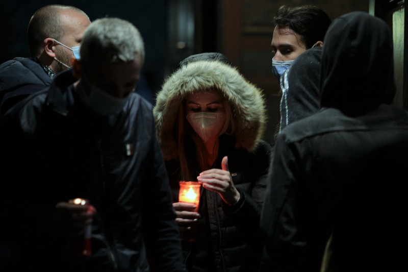 O femeie păzeşte flacăra candelei de ploaie