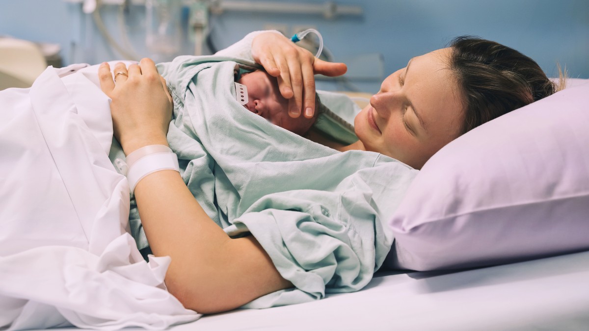 Tânără mamă își îmbrățișează nou-născutul după naștere