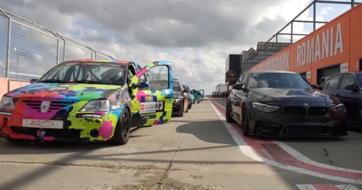 Mașini de curse, colorate, parcate pe pista circuitului MotorPark România de la Adâncata, în față un Logan și un BMW de culoare neagră