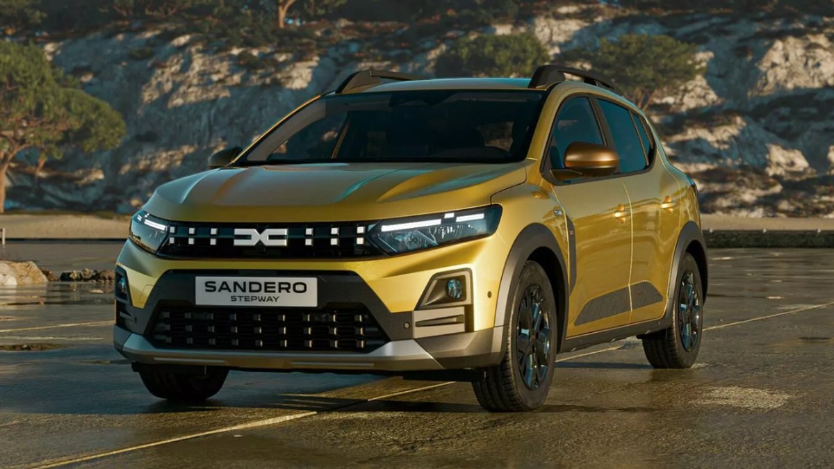 Automobilul din imagine este un Dacia Sandero Stepway, vopsit într-o nuanță metalizată de auriu, cu un design modern și elemente specifice unui crossover urban. Mașina este fotografiată într-un decor natural, având în fundal stânci și vegetație, ceea ce îi pune în valoare aspectul robust și garda la sol mai înaltă.
