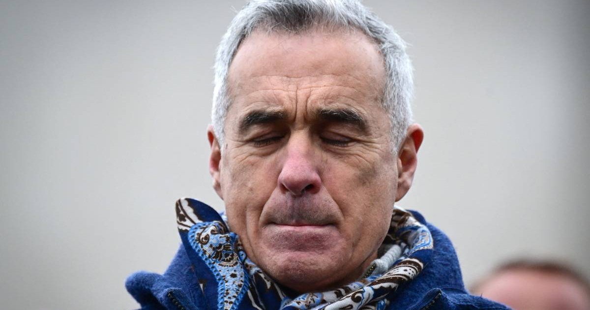 calin georgescu cu o figura incruntata purtand un pulover albastru si un fular la gat