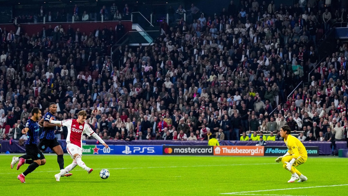 Imagine cu un fotbalist al echipei Ajax Amsterdam în timp ce șutează. În dreapta se află portarul Inter Milano, iar în spatele celui de la Ajax sunt alți doi fotbaliști
