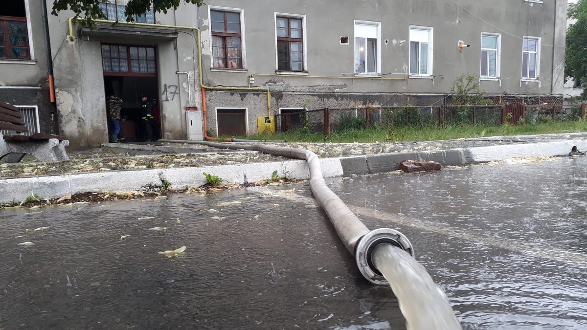 Doi drumari mută cu lopata apa strânsă pe marginea drumului pe un șantier din Timișoara