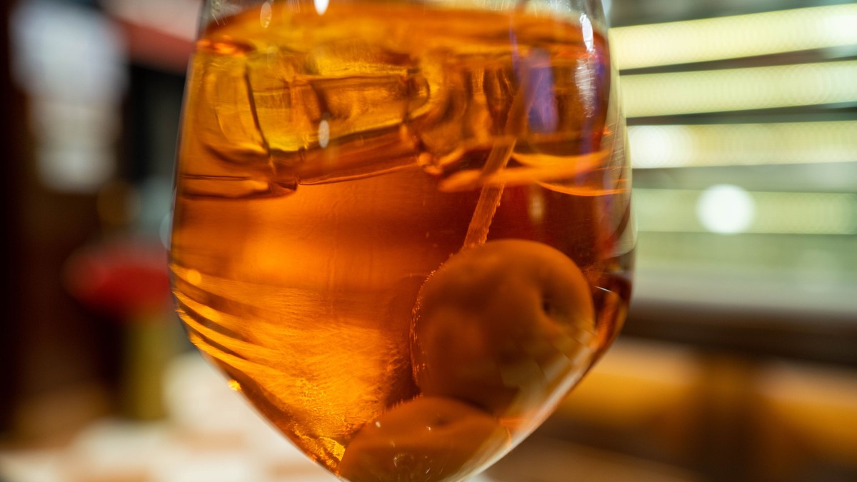 pahar cu cocktail aperol spritz, cu geață, într-un pahar cu picior