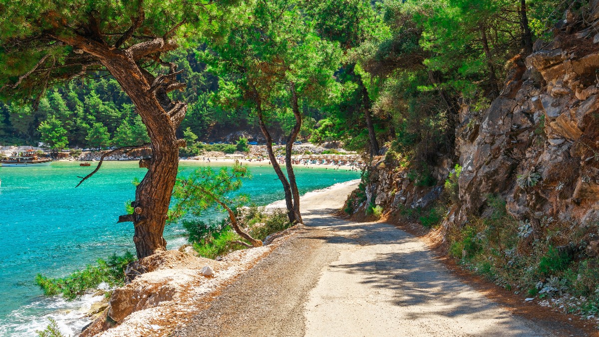 Insula Thassos din Grecia, o plajă pustie la care turiștii trebuie sa ajungă pe un drum pe lângă stânci
