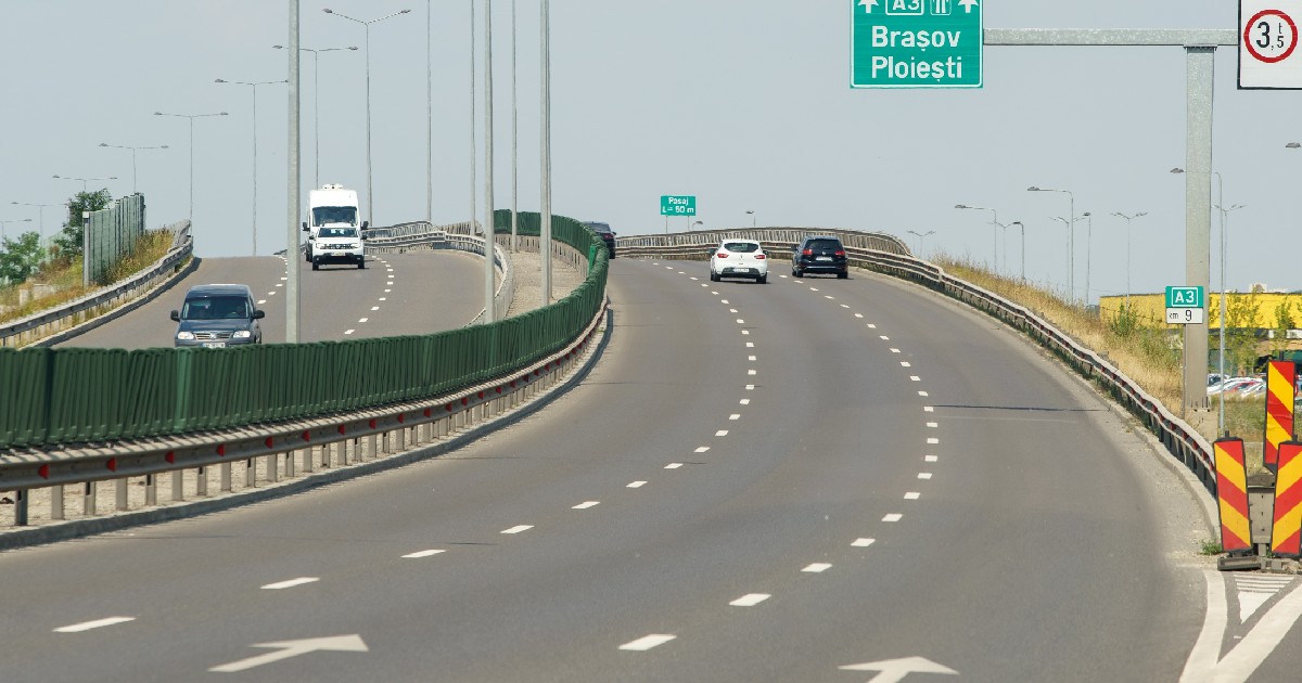 Imaginea surprinde o secțiune a autostrăzii A3 din România, prezentând un pasaj rutier cu mai multe benzi și indicatoare rutiere care direcționează traficul către orașele Brașov și Ploiești.