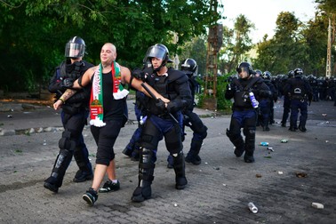 epa04913469 A Hungarian soccer fan is led away by Hungarian police officers prior to the UEFA Euro 2016 qualifying Group F soccer match between Hungary and Romania near the Groupama Arena, Budapest, Hungary, 04 September 2015. EPA/JANOS MARJAI HUNGARY OUT