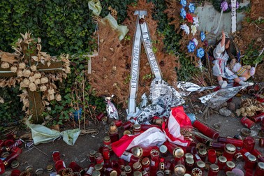 O coroană uscată, pe care scrie “A murit un înger, a renăscut o țară”, se află rezemată de casa în care Dincă spune că a ucis-o pe Alexandra