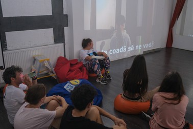 Mai mulți tineri urmăresc melodia lui Samy, într-una din încăperile de la Studiourile Ferentari