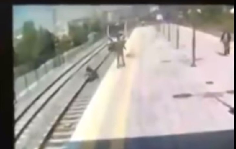 VIDEO/ Momentul în care un bărbat sare în fața trenului ca să salveze o tânără care voia să se sinucidă