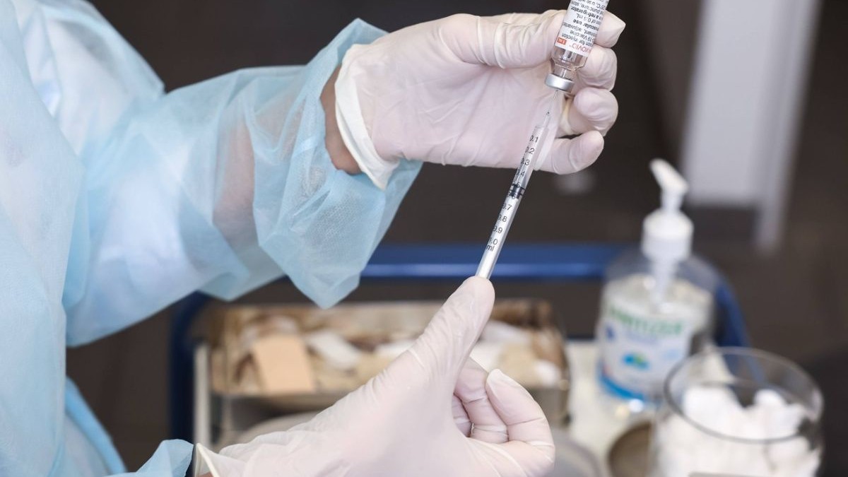 Asistent medical trage vaccin în seringă
