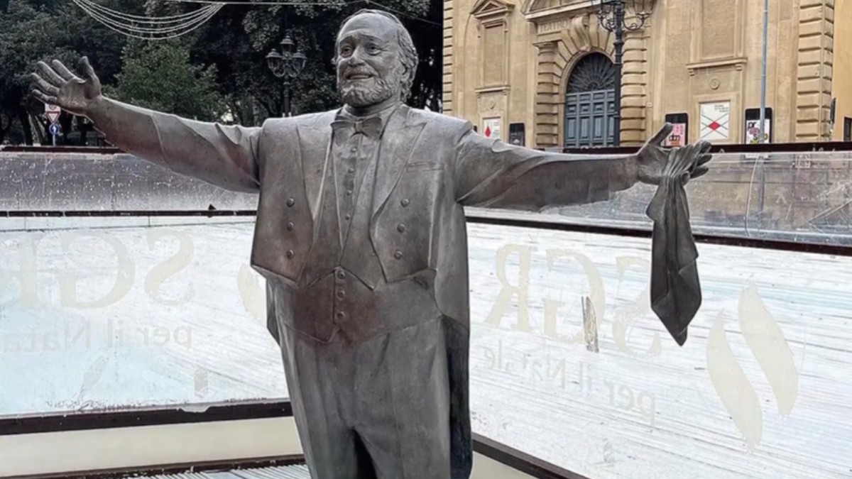Statuia lui Luciano Pavarotti în interiorul unui patinoar.
