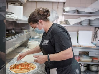 Rocsana prepară o pizza în restaurantul ei din Lagos, Portugalia