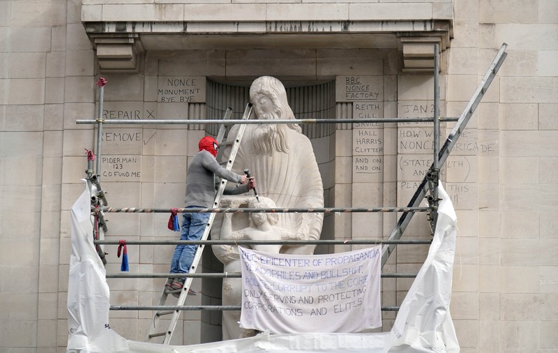 Un bărbat s-a urcat pe schelele din fața sediului BBC și a lovit cu dalta și ciocanul o statuie controversată | VIDEO