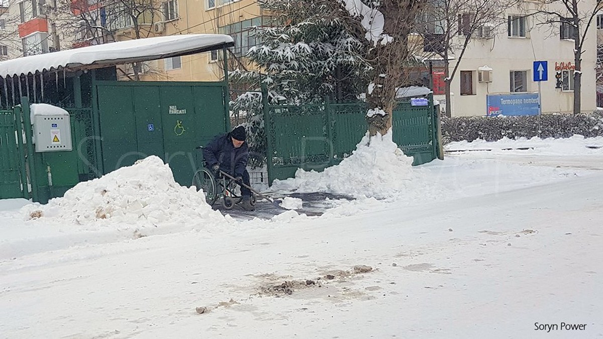 Un bărbat în scaun cu rotile a deszăpezit trotuarul din fața casei în Buzău