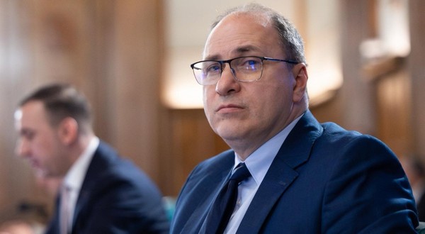 Mihai Dimian, ministrul interimar al Educatiei, în Guvernul României. Poartă un costum albastru și o pereche de ochelari