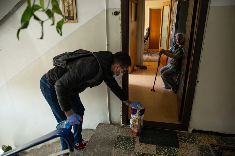 Alex a lăsat cumpărăturile la ușă, stând la distanță de bătrână