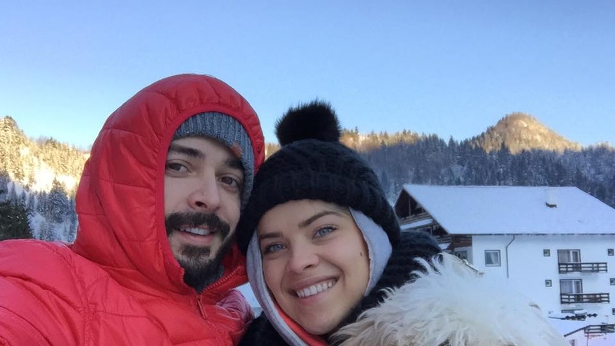 Bianca Lăpuște și Marius Moga, alături de cățelul lor, se pozează afară la zăpadă