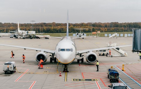 Un avion pe pistă. Imaginea surprinde activitatea personalului de la sol care pregătește avionul pentru decolare.