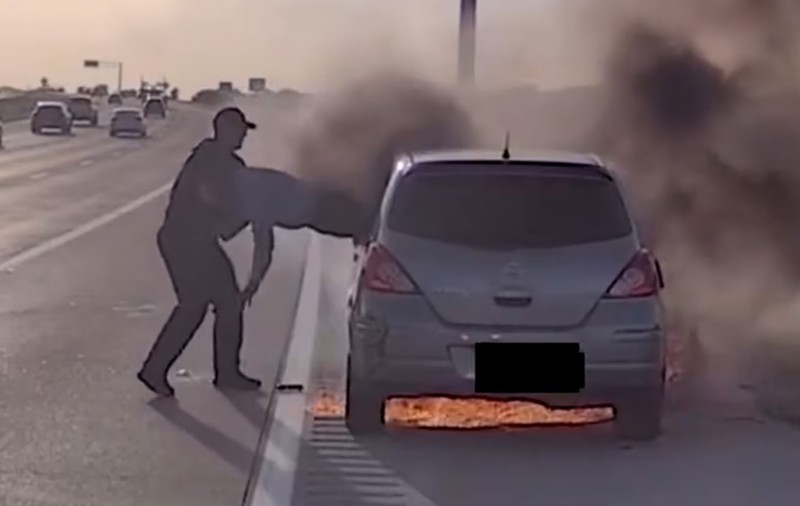 Momentul în care un polițist ajută un șofer să iasă pe geam, după ce mașina în care se afla a luat foc, pe o autostradă din Texas