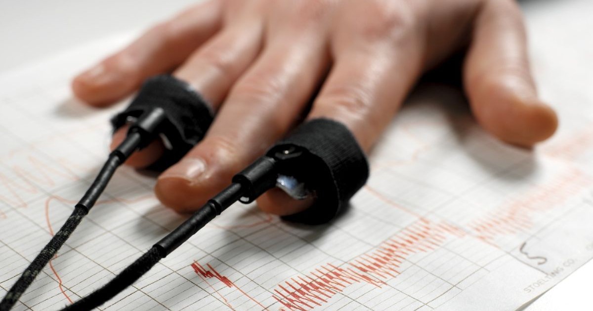 Testul detectorului de minciuni. Contoare de puls pe degetele unui bărbat utilizate pentru un test de detector de minciuni sau poligraf. Sub mâinile subiectului se află urmele produse de poligraf. Sursă foto: Profimedia