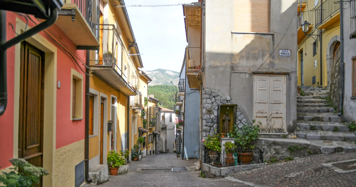 O stradă plină de case în Latronico, Italia, drumul este pavat cu piatră