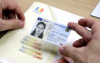 Un bărbat ține în mână o carte electronică de identitate