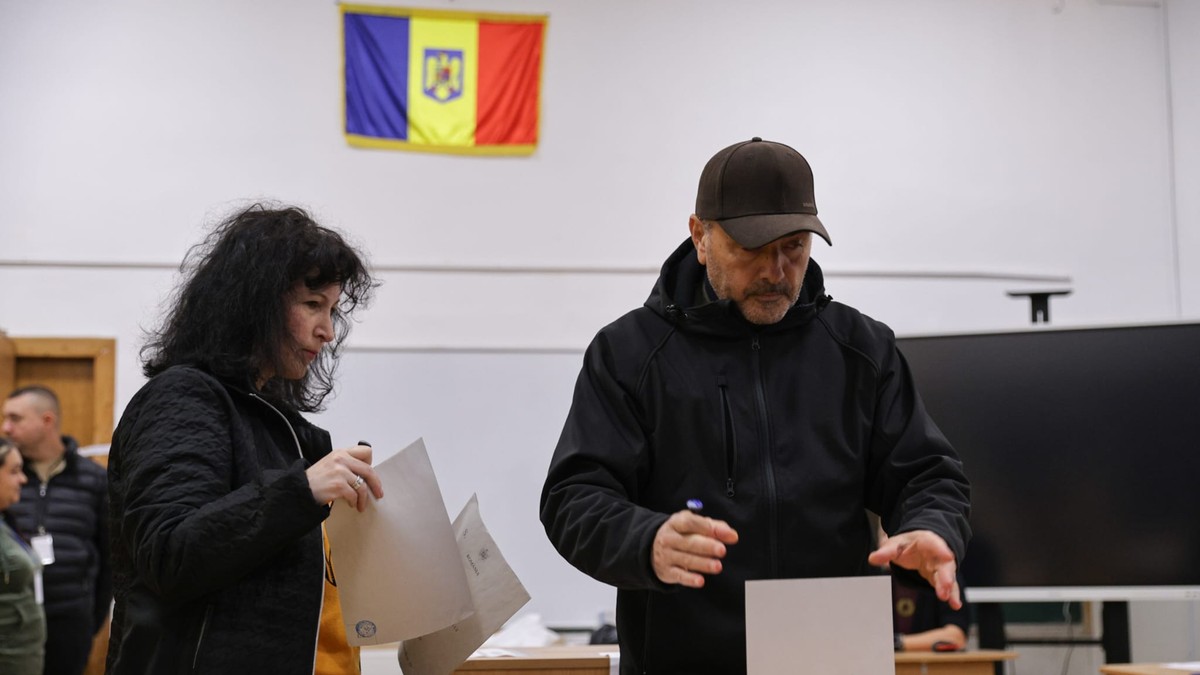 Două persoane introduc buletinul în urna de vot