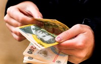 O tânără care numără mai multe bancnote de 200 de lei 