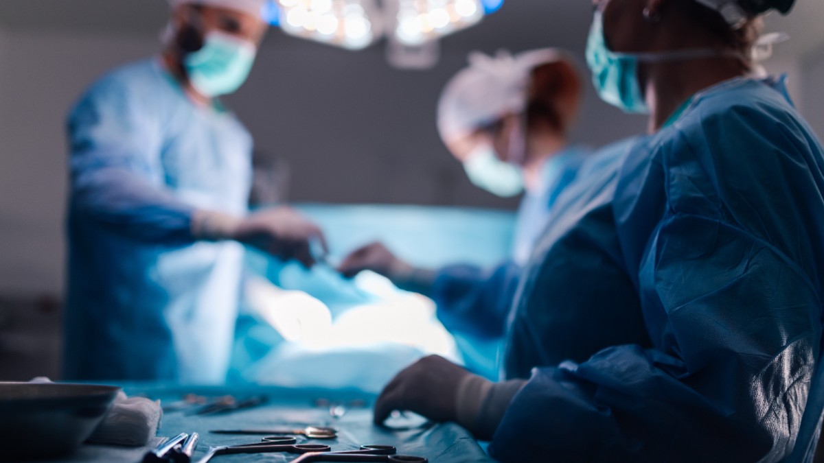 Doctori aflați în sala de operație, cu echipament albastru