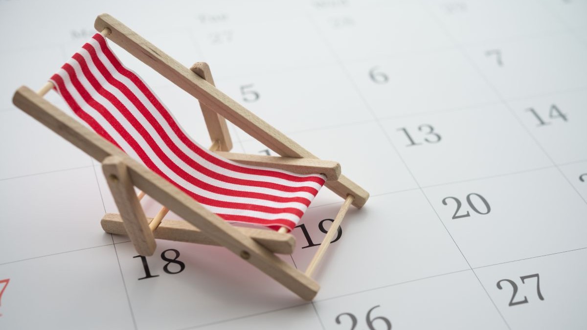 Șezlong cu dungi roșii și albe peste un calendar, imagine creativă care arată minivacanță și perioada de concediu