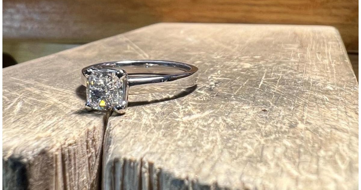 Giuvaierul - poza cu un inel de logodna cu diamant asezat pe un butuc de lemn