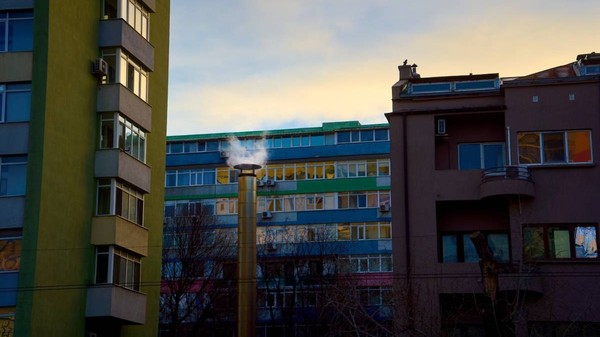 București, România 7 ianuarie 2025  Emisii de la un coș de fum înalt între blocuri de apartamente din București
