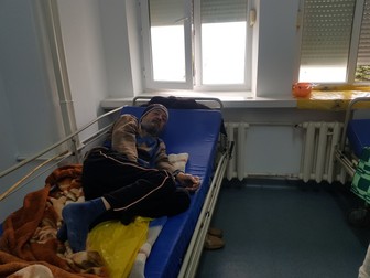 Dima stă ghemuit pe patul de spital