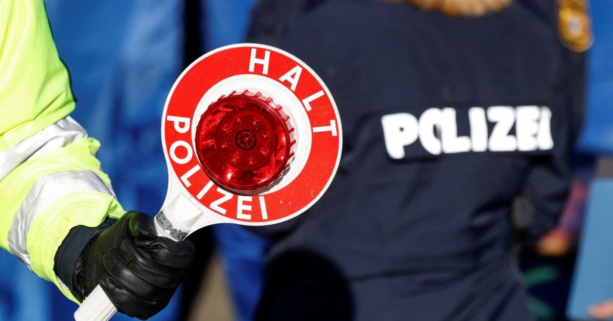 Un ofițer de poliție german prezintă discul de semnalizare al poliției în timpul unui control la un post de control de frontieră, 6 februarie 2025.