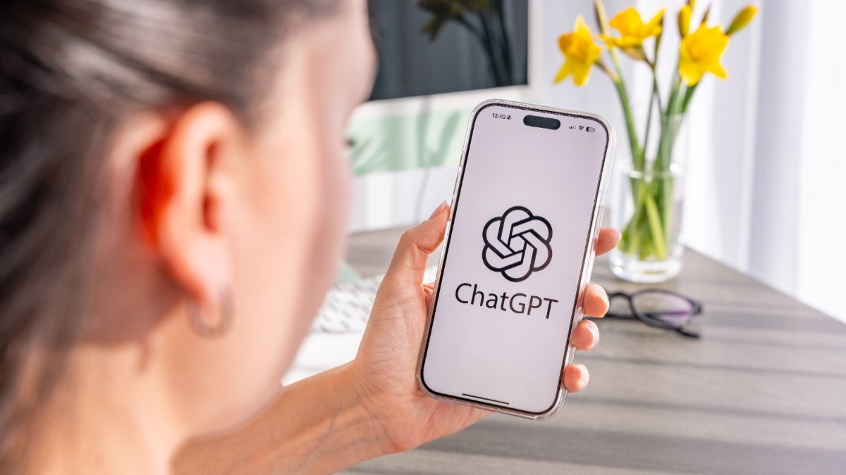 O femeie care ține un telefon în mână pe care este accesat ChatGPT