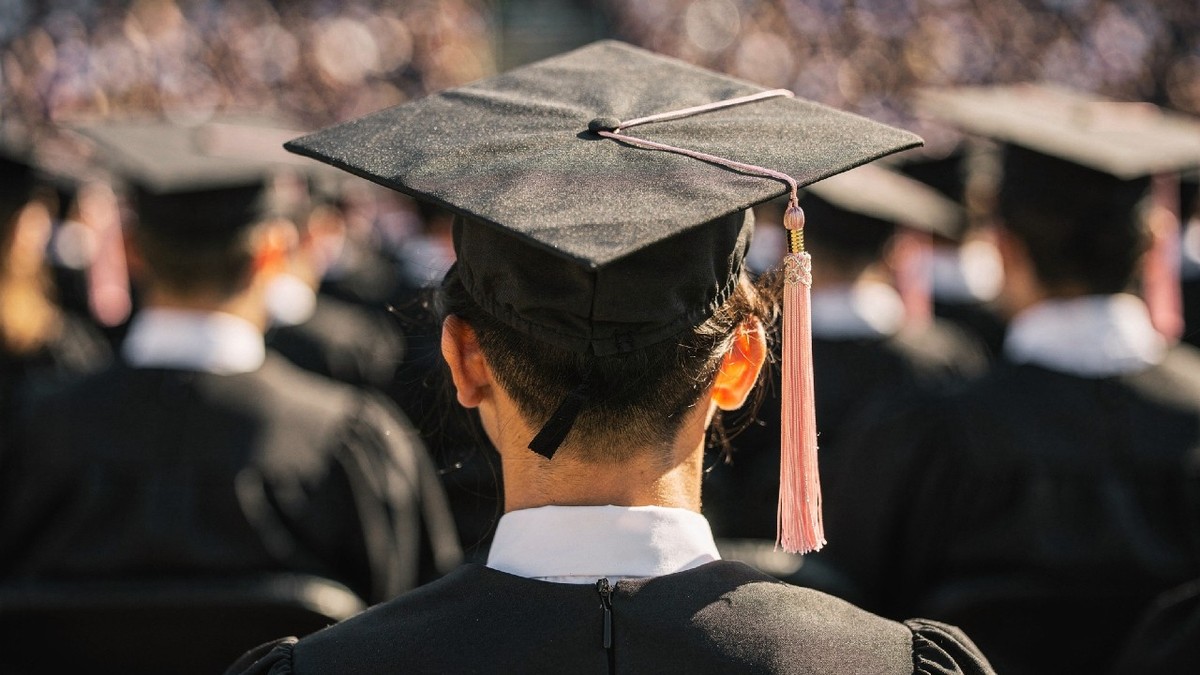 Vedere a unui absolvent de facultate care poartă pălărie și robă la ceremonia de absolvire