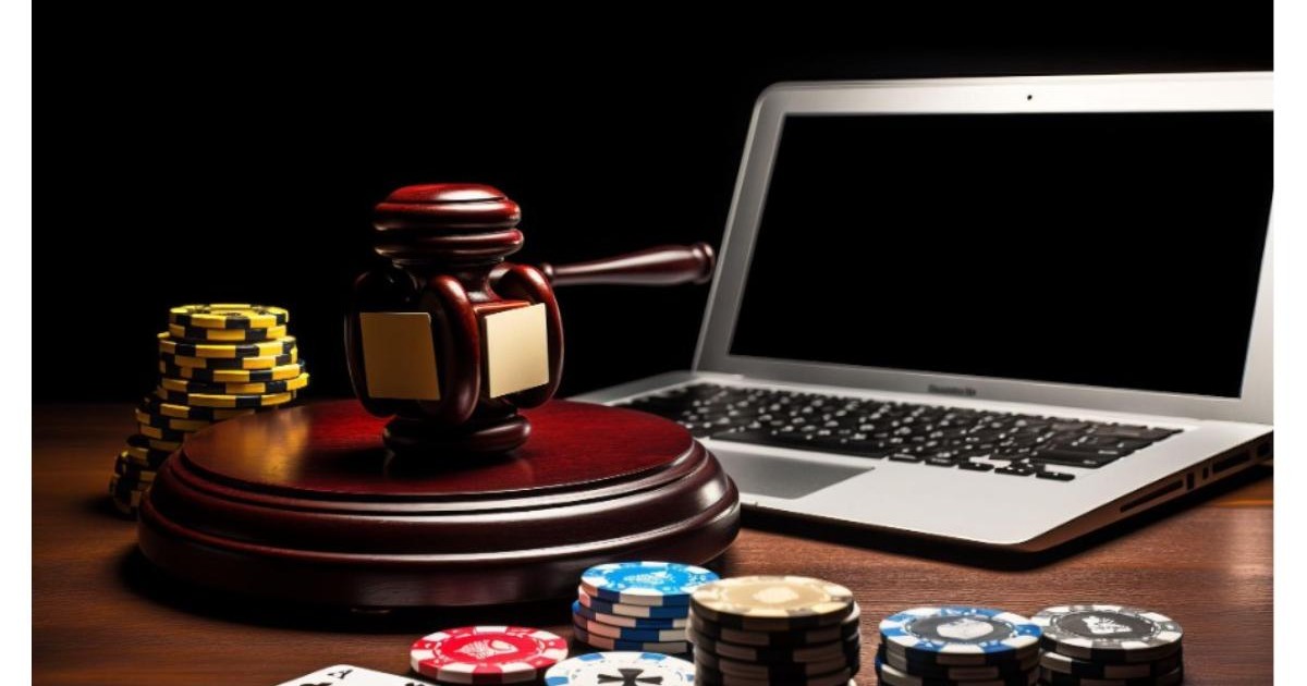 Sevenslots - laptop asezat pe o masa de lemn, cu ecranul ridicat, avand un cicocan judecatoresc in faya si piese de poker asezate dezordonat pe masa