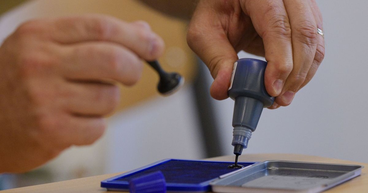 Un barbat toarna cerneala pe o tusiera in timpul alegerilor locale si europarlamentare, intr-o sectie de votare din Bucuresti, duminica, 9 iunie 2024