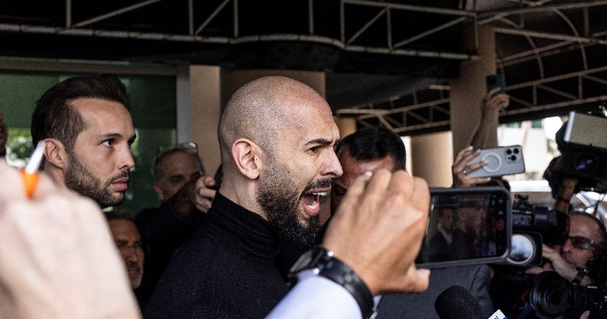 Un bărbat îmbrăcat în negru, cu barbă și capul ras, Andrew Tate, țipă în fața unor jurnaliști