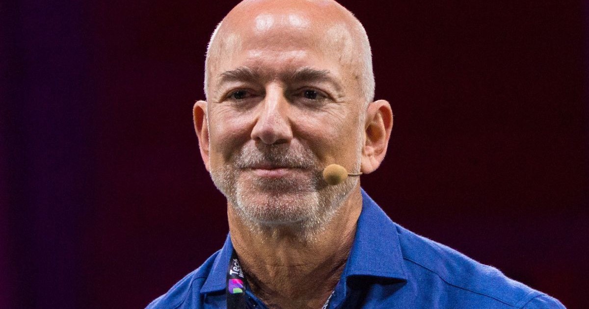 Jeff Bezos, îmbrăcat într-un tricou albastru și purtând un microfon, pe scena Italian Tech Week.